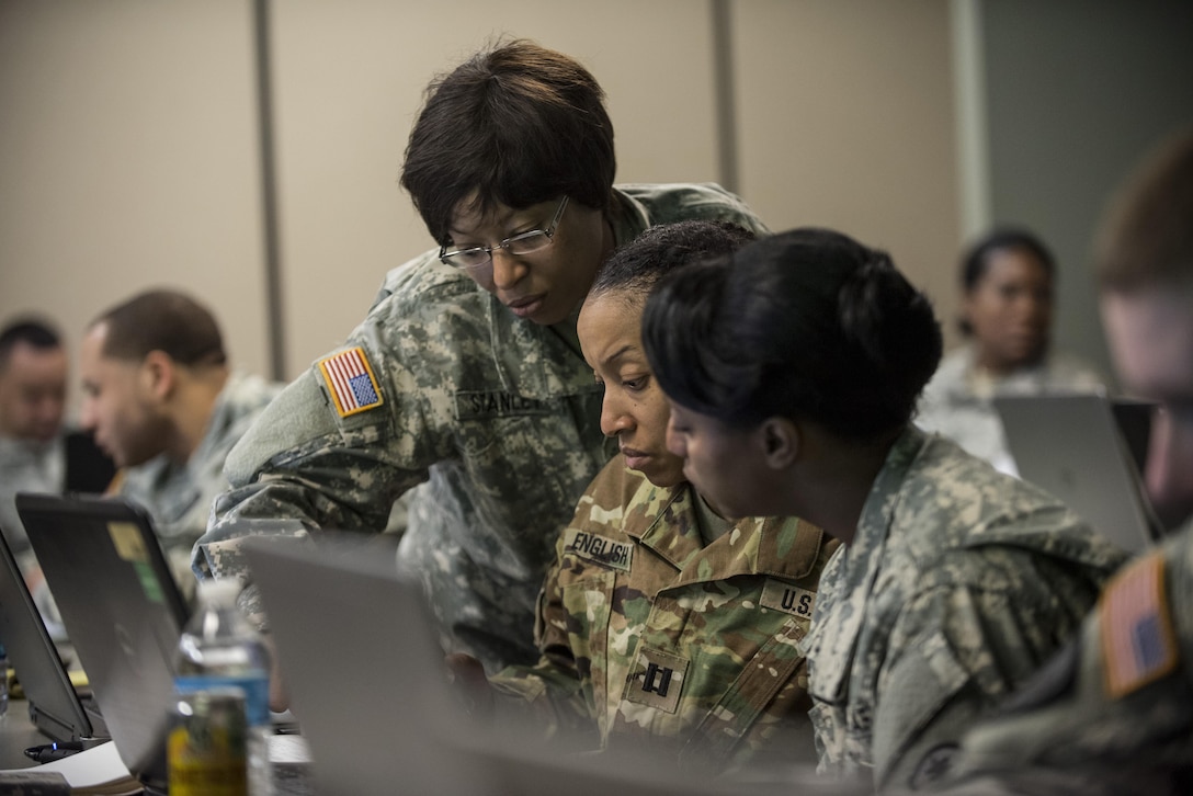 Sgt. 1st Class Sucrontay Stanley (left), works with Capt. Tahera English and Capt. DeMonica Nealy, all personnel officers and noncommissioned officers from different U.S. Army Reserve military police units, work together on updating personnel data for their units during a four-day workshop and Yearly Training Brief conference held by the 200th Military Police Command in Columbus, Ohio, on March 31. During the event, the units' leaders worked to improve their readiness and briefed the commanding general and his command leadership on their units' status. (U.S. Army photo by Master Sgt. Michel Sauret)