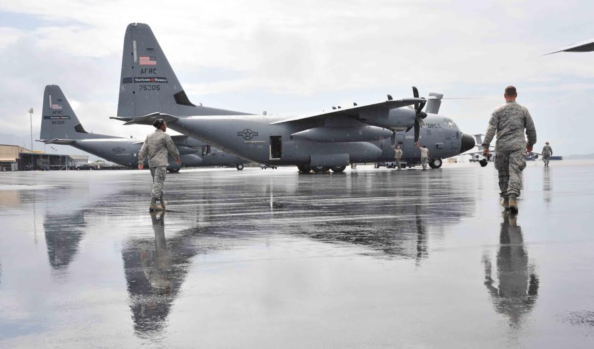 Maintenance members with the 403rd Maintenance Group walk out to recover a WC-130J that returned from a weather reconnaissance mission into Tropical Storm Guillermo Aug. 5, 2015. The maintainers deployed to Joint Base Pearl Harbor-Hickam, Hawaii, with the 53rd Weather Reconnaissance Squadron, assigned to the 403rd Wing at Keesler Air Force Base, Mississippi. (U.S. Air Force photo/Maj. Marnee A.C. Losurdo)