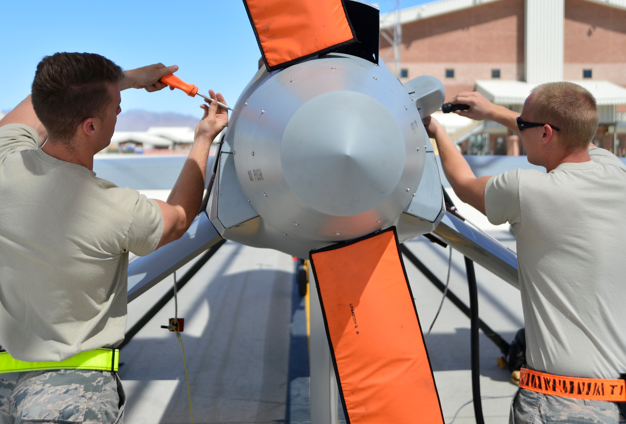 Staff Sgt. Ken, left, and Senior Airman Jonathan, right, both 432nd Aircraft Maintenance Squadron MQ-1 Predator crew chiefs, take off an engine panel during a post-flight check April 5, 2015 at Creech Air Force Base, Nevada. Crew chiefs are responsible for supervising, monitoring, and directing aircraft maintenance. (U.S. Air Force photo by Senior Airman Christian Clausen/Released)
