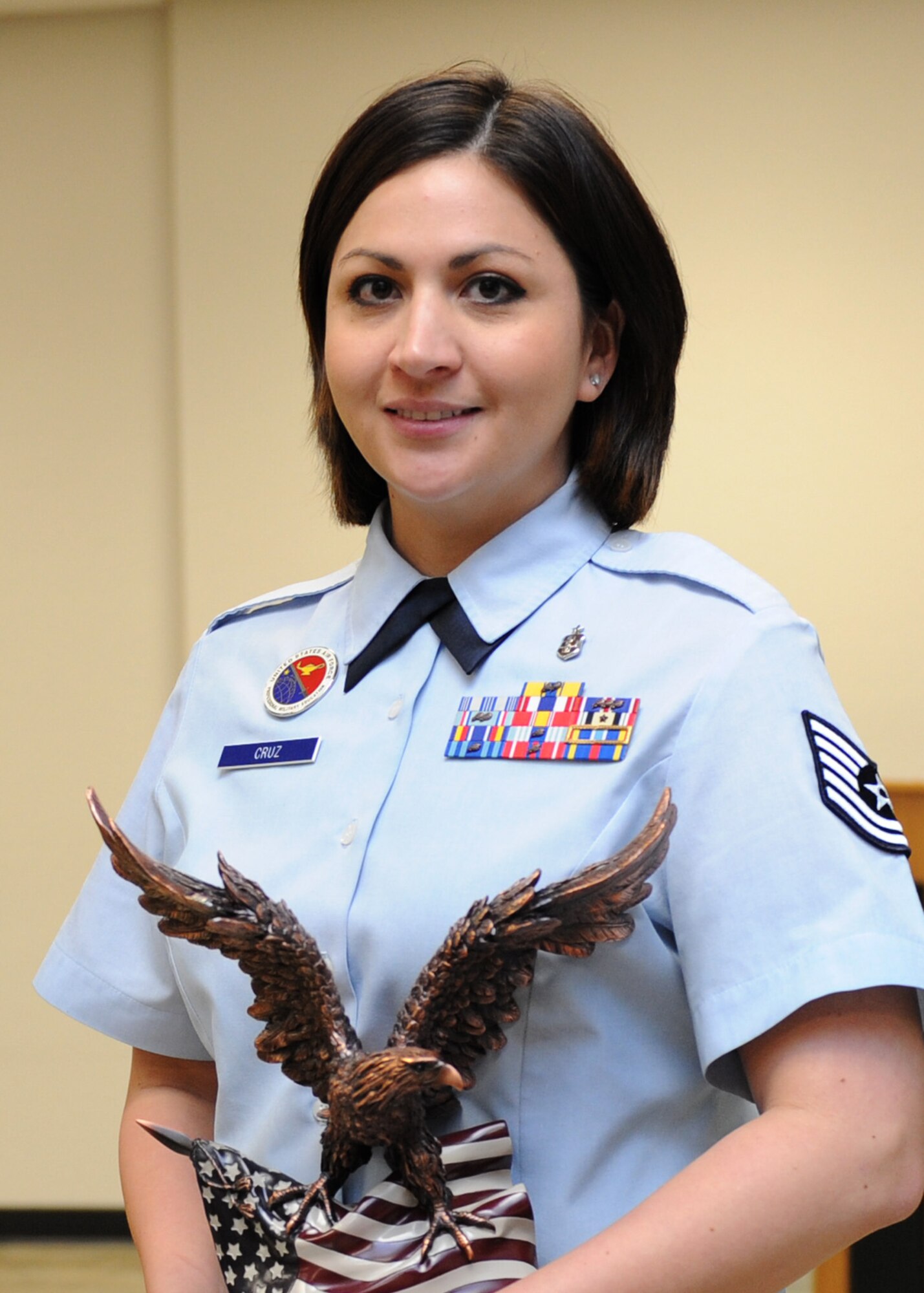 Tech. Sgt. Cassandra Cruz, 81st Force Support Squadron airman leadership school instructor, holds a 2nd Air Force annual award trophy at the ALS building April 4, 2016, Keesler Air Force Base, Miss. Leadership from 2nd AF and the 81st Training Wing traveled to Cruz’s work area to congratulate her on her accomplishments. (U.S. Air Force photo by Kemberly Groue)