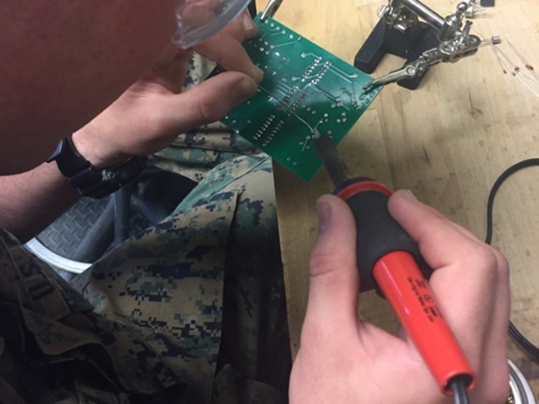A Marine attached to Basic Engineer Equipment Electrical Systems Technician course 4-16 (BEEEST 4-16) aboard Marine Corps Engineer School, Camp Lejeune, N.C. repairs a circuit card using a soldering method.    
