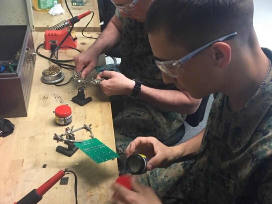 Marines attached to Basic Engineer Equipment Electrical Systems Technician course 4-16 (BEEEST 4-16) aboard Marine Corps Engineer School, Camp Lejeune, N.C. repair a circuit card using a soldering method as part of a practical application. 
