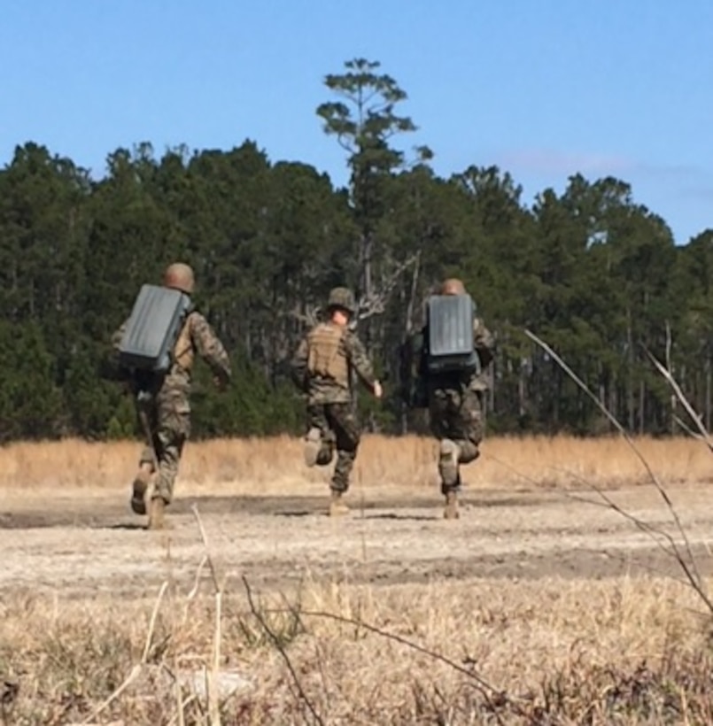 A Combat Engineer Instruction Company (CEIC) instructor and Second Lieutenants Ryan Gibbs and Jay Ringenbach, Marines attached to Combat Engineer Officer course 2-16 (CEO 2-16);  run to emplace the Anti-Personnel Obstacle Breaching System (APOBS). The system is a rocket propelled line charge composed of 108 grenades that can clear a 45 meter by 1 meter path through mines and wire obstacles. 
