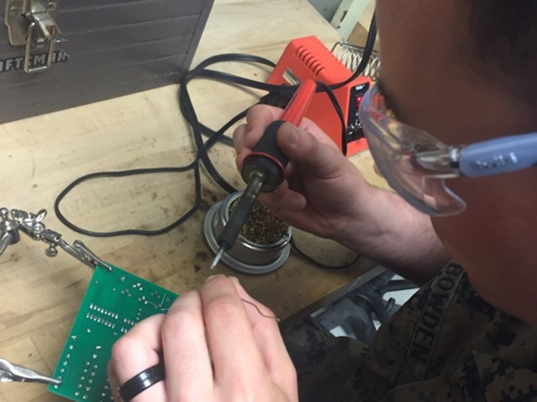 Private First Class Bradley C. Bowden, a Marine attached to Basic Engineer Equipment Electrical Systems Technician course 4-16 (BEEEST 4-16) aboard Marine Corps Engineer School, Camp Lejeune, N.C.; uses the soldering method to repair a broken circuit card.   

