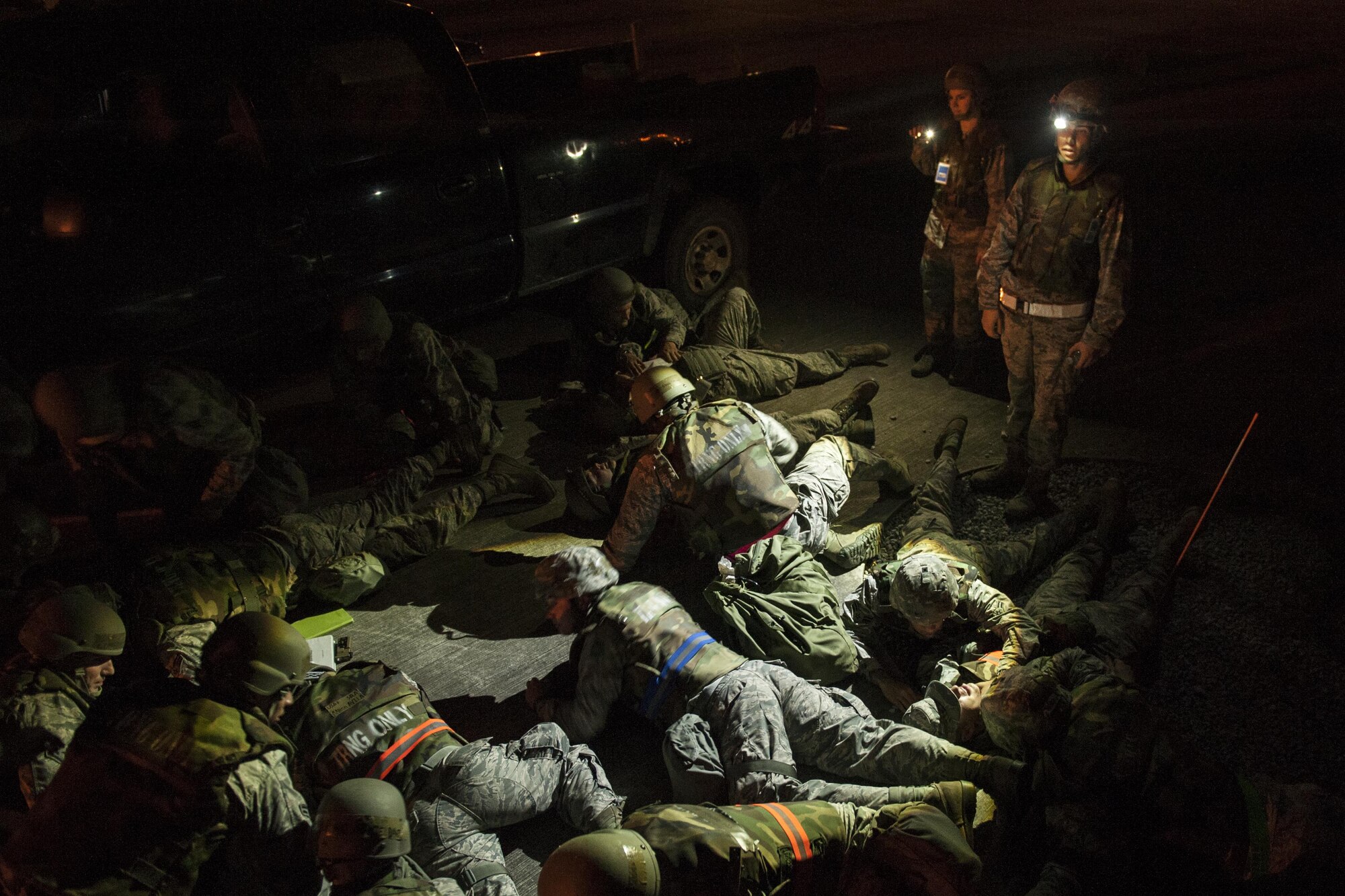 U.S. Air Force Airmen from the 18th Civil Engineer Squadron perform self-aid and buddy care after a simulated attack during a training exercise at the Silver Flag training site April 5, 2016, on Kadena Air Base, Japan. Members with the 18th CES enhanced unit readiness by conducting nighttime airfield damage repair training in conjunction with SABC scenarios. (U.S. Air Force photo by Senior Airman Peter Reft/Released)