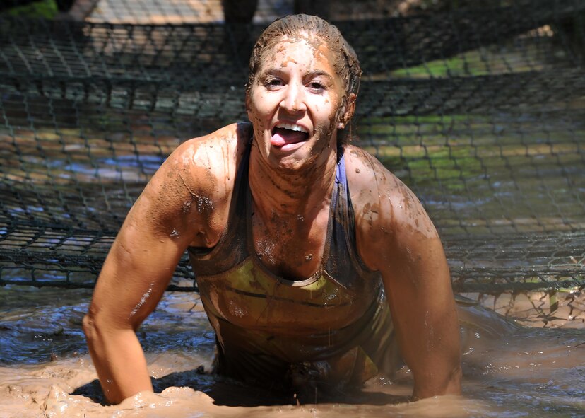 Senior Airman Kimberly Brister, 2nd Aerospace Medicine Squadron flight medicine technician, climbs out of a mud pit after crawling under a cargo net during the 2016 Defenders of Liberty Mud run at Barksdale Air Force Base, La., April 2. Mud run participants ran a 4-mile course through hilly terrain, conquering 20 obstacles along the way. (U.S. Air Force photo/Senior Airman Joseph Raatz)