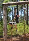 A 2016 Defenders of Liberty Mud Run participant rings a bell after climbing a 15-foot rope at Barksdale Air Force Base, La., April 2. This year’s course featured 20 obstacles designed to test the physical and mental limits of participants, and included wooden structures, multiple rope climbs and mud pits. (U.S. Air Force photo/Senior Airman Joseph Raatz)