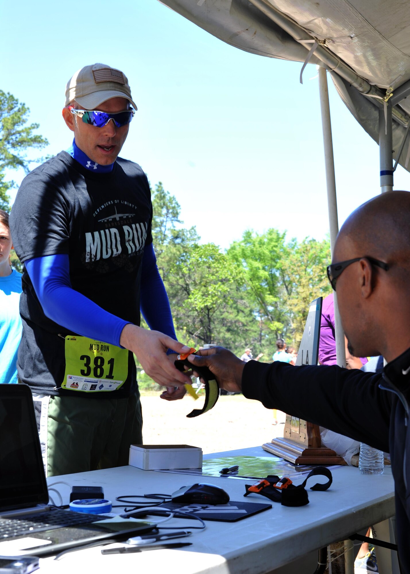 A contestant picks up his race tracker from the registration table at the 2016 Barksdale Air Force Base, La., Defenders of Liberty Mud Run, April 2. More than 500 people came out to run the 4-mile course, each of whom received an official time thanks to their race tracker. These times were logged and made accessible by the 2nd Force Support Squadron. (U.S. Air Force photo/Senior Airman Joseph Raatz)