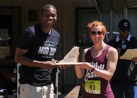Kendra Phillips, 2016 Defenders of Liberty Mud Run top female finisher, poses with Col. Brandon Parker, 2nd Bomb Wing vice commander, at Barksdale Air Force Base, La., April 2. Phillips finished the 4-mile race with a time of 45:43. (U.S. Air Force photo/Senior Airman Joseph Raatz)