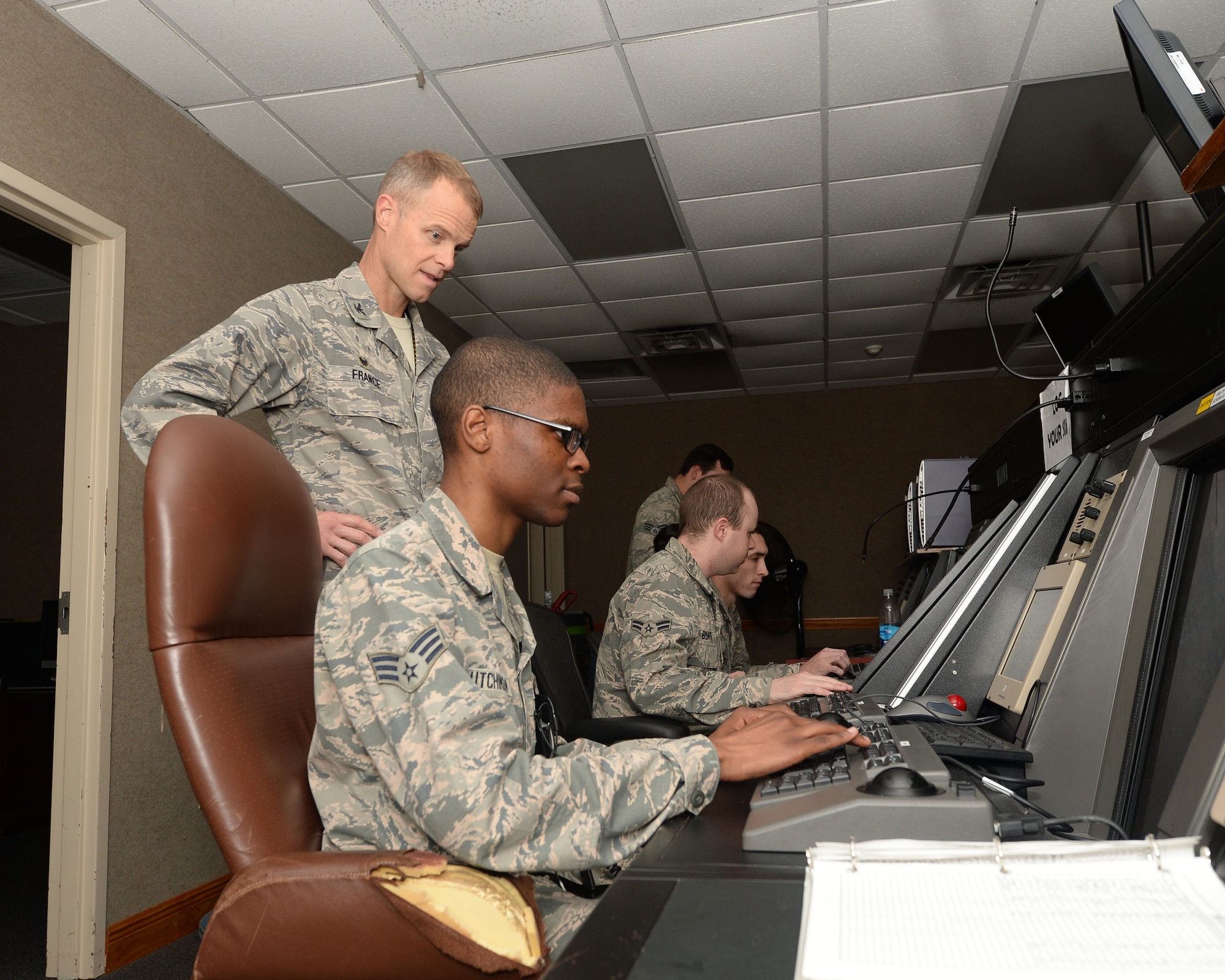 During the Airman’s Shadow Program, Col. Derek C. France, 325th Fighter Wing commander, observes Senior Airman Jonathan Hutchinson, 325th Operations Support Squadron air traffic controller, while he runs a simulation that trains air traffic controller trainees on how to coordinate jets in the air March 29, 2016. The Airman's Shadow program is a 325th FW commander program designed to recognize members of Team Tyndall. The program provides an opportunity for the commander to meet with the Airmen and get a first-hand look at what Tyndall Airmen are doing. (U.S. Air Force photo by Airman 1st Class Cody R. Miller/Released)