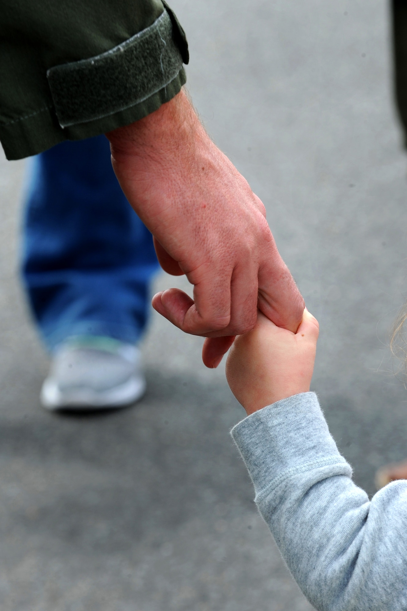 A parent and child hold hands during the Month of the Military Child Parade at Barksdale Air Force Base, La., April 1. Each year, the Child Development Center hosts several events throughout the month of April to recognize the challenges military children face. (U.S. Air Force photo/Airman Alexis C. Frost)