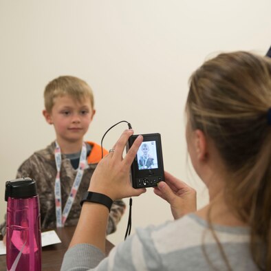 A child has his picture taken for his Gunfighter Jr. passport April 4, 2016, at Mountain Home Air Force Base, Idaho. Gunfighter Jr. allowed children of service members to experience what their parent does to prepare for a deployment. (U.S. Air Force photo by Senior Airman Malissa Lott/RELEASED)