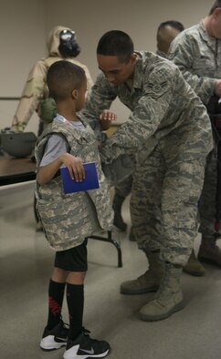A child tries on Kevlar as part of the Gunfighter Jr. event April 4, 2016, at Mountain Home Air Force Base, Idaho. Gunfighter Jr. provided the children with their own Gunfighter Jr. passports and their own "readiness bags" full of prizes. (U.S. Air Force photo by Senior Airman Malissa Lott/RELEASED)