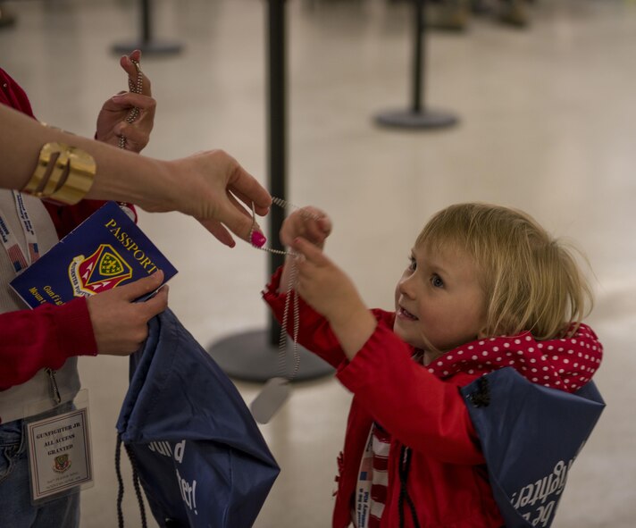 A child recieves dog tags, a passport, and a readiness bag filled with other items April 4, 2016, at Mountain Home Air Force Base, Idaho. The goodies were given to children who walked through the mock deployment line. (U.S. Air Force photo by Airman Alaysia Berry/Released)