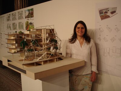 Army Sergeant Mariela Payan, 841st Transportation Battalion documentation non-commissioned officer, poses in front of her personal project; a scale model of a waterfront residential building design at the Academy of Fine Arts in Vienna, Austria, in June 2007. Before Payan joined the Army, she earned  a Bachelor’s Degree in Architecture. Payan was recognized during Women’s History Month for her overall professional skill and the importance of her job to the base and the rest of the East Coast. (U.S. Air Force photo/Airman 1st Class Thomas T. Charlton)