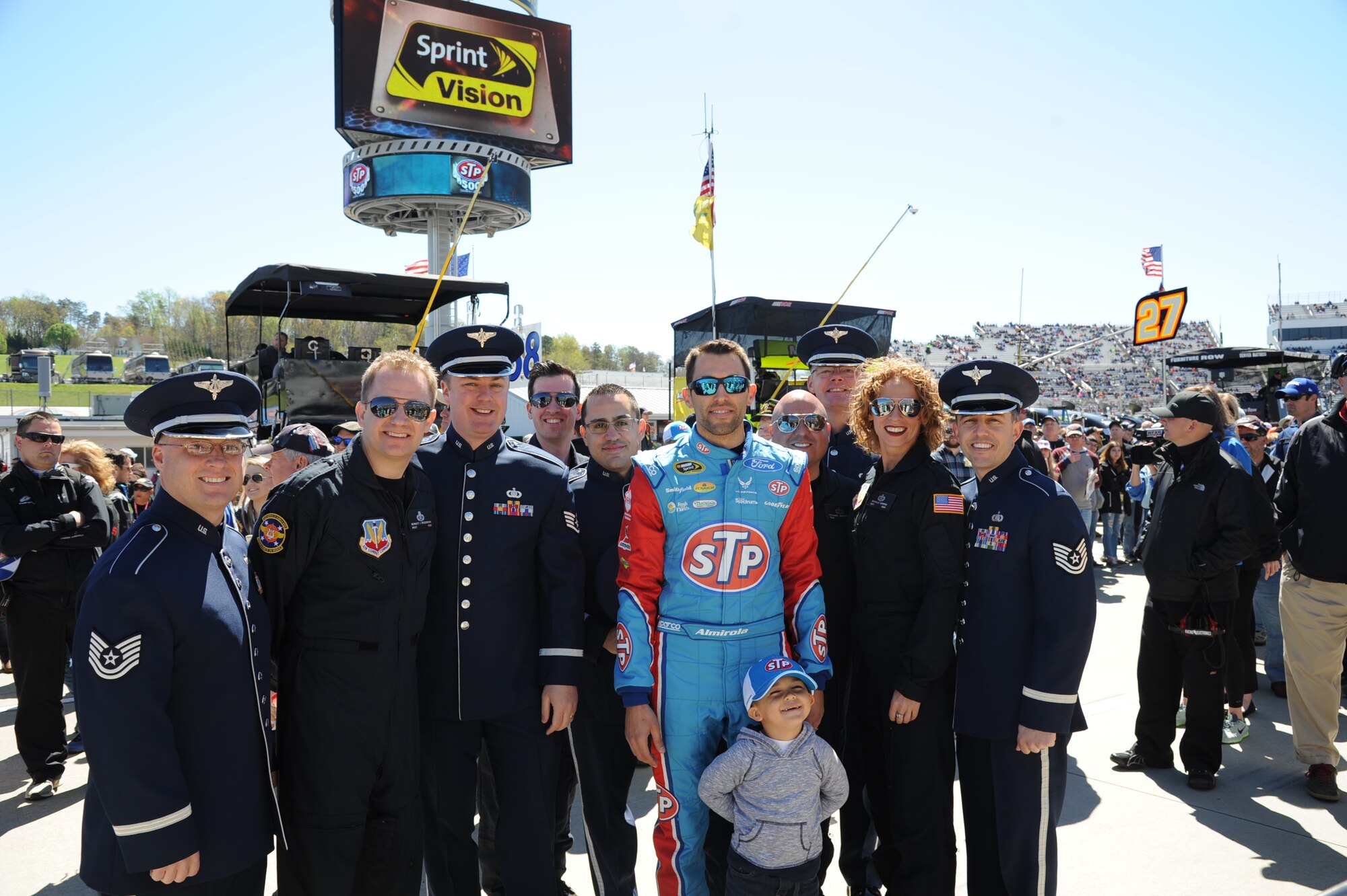 U.S. Air Force Heritage of America Band, Full Spectrum and Heritage brass members pose for a photograph with a NASCAR driver at Martinsville, Va., April 3, 2016.  The bands performed during a pre-race celebration which, also coincided with the commemoration of the 50th anniversary of the Vietnam War. (U.S. Air Force photo by Staff Sgt. William Anger)


