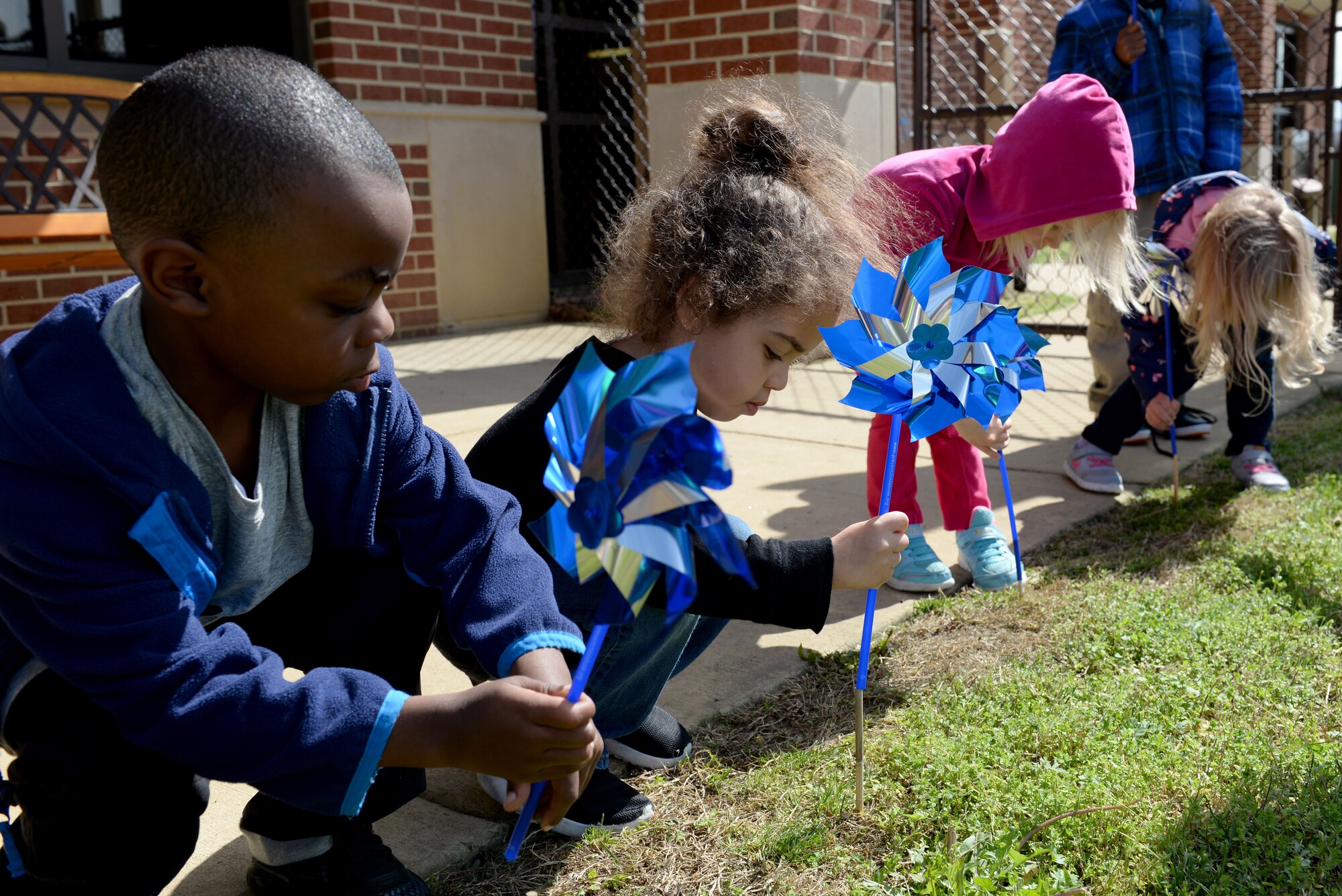 Children plant pinwheels as part of National Child Abuse Prevention Month at Langley Air Force Base, Va., April 1, 2016. The Joint Base Langley-Eustis Family Advocacy Program will host events throughout the month to provide parents with child safety lessons, tips and support.  (U.S. Air Force photo by Airman 1st Class Kaylee Dubois)