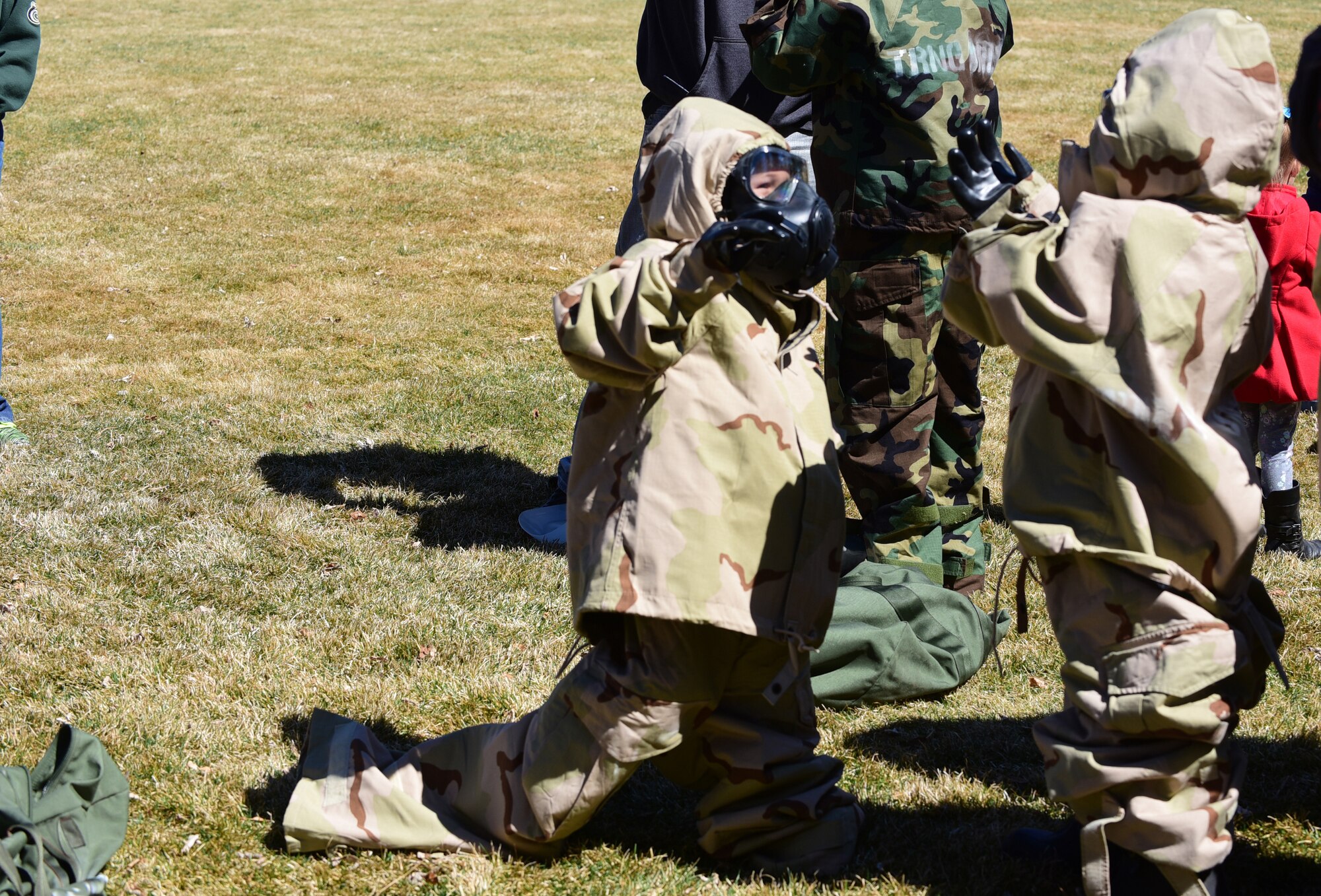 PETERSON AIR FORCE BASE, Colo. - Children try on mission oriented protective posture or MOPP gear during the 21st Force Support Squadron’s Kids Understanding Deployment Operations event at Peterson Air Force Base, Apr. 2, 2016. K.U.D.O.S. afforded the children of Team Pete the opportunity to experience the unique skills of several different units on base including Security Forces, Medical, Fire Protection and Bioenvironmental. (U.S. Air Force photo by Staff Sgt. Amber Grimm)