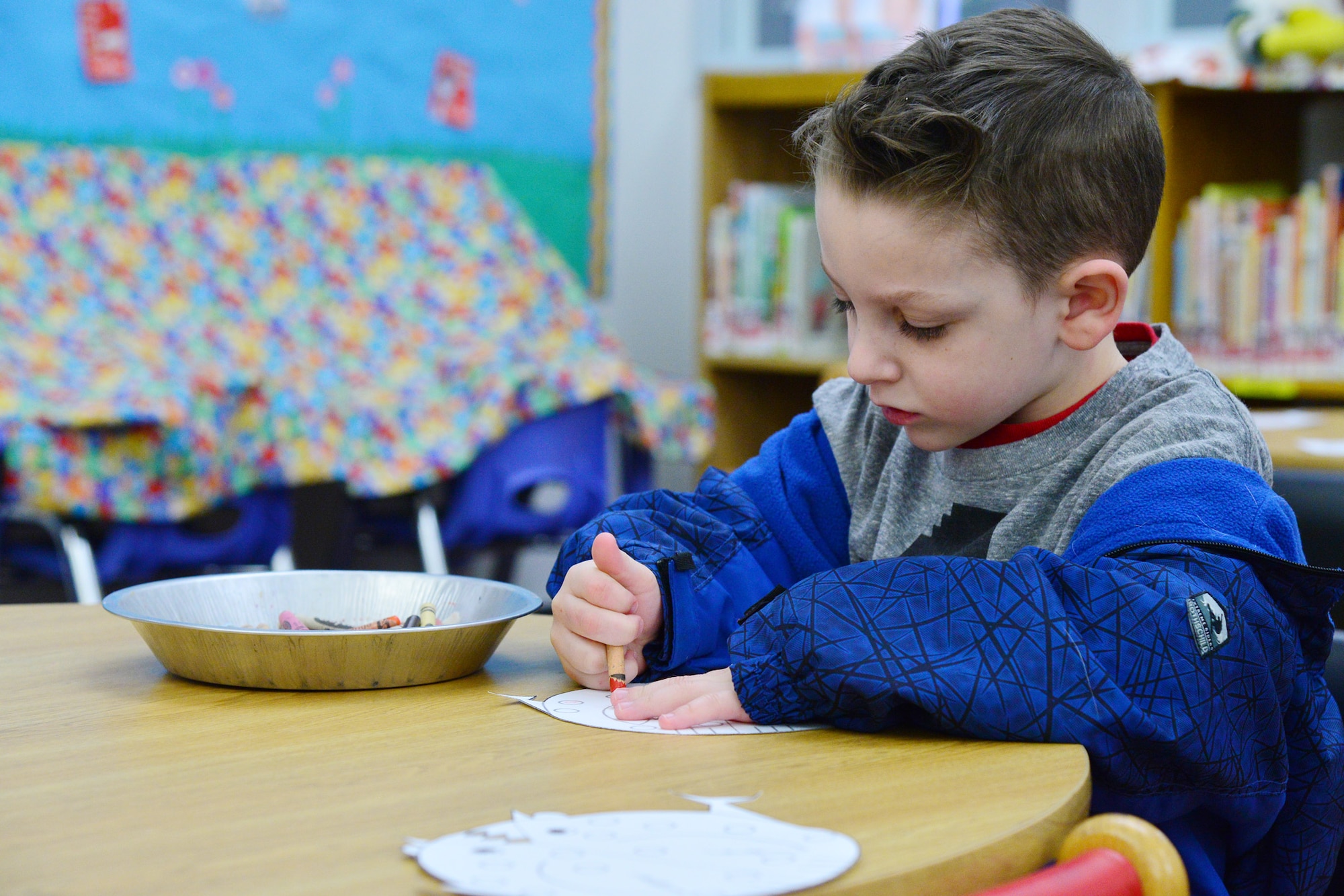 A child at the library colors a paper chicken during the crafting portion of story time April 5, 2016, at Malmstrom Air Force Base, Mont. Every Tuesday the base library hosts a story time event, reading weekly themed books to children ages two to six years old. After the stories are read, children can create crafts related to the theme of the book. (U.S. Air Force photo/Airman Daniel Brosam)