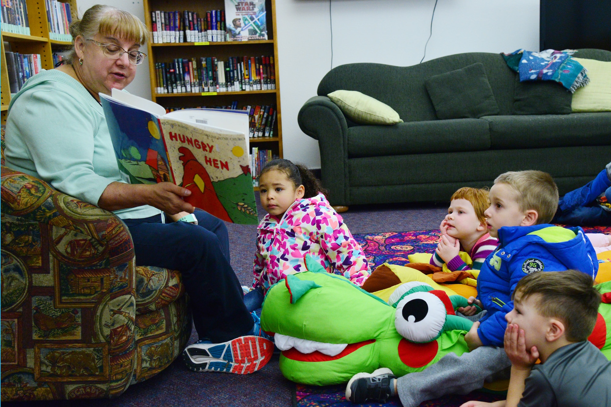Linda “Dixie” Paronto, 341st Force Support Squadron base librarian, reads to children at the library during story time April 5, 2016, at Malmstrom Air Force Base Mont. Every Tuesday the base library hosts a story time event, reading weekly themed books to children ages two to six years old. After the stories are read, children can create crafts related to the theme of the book. (U.S. Air Force photo/Airman Daniel Brosam)
