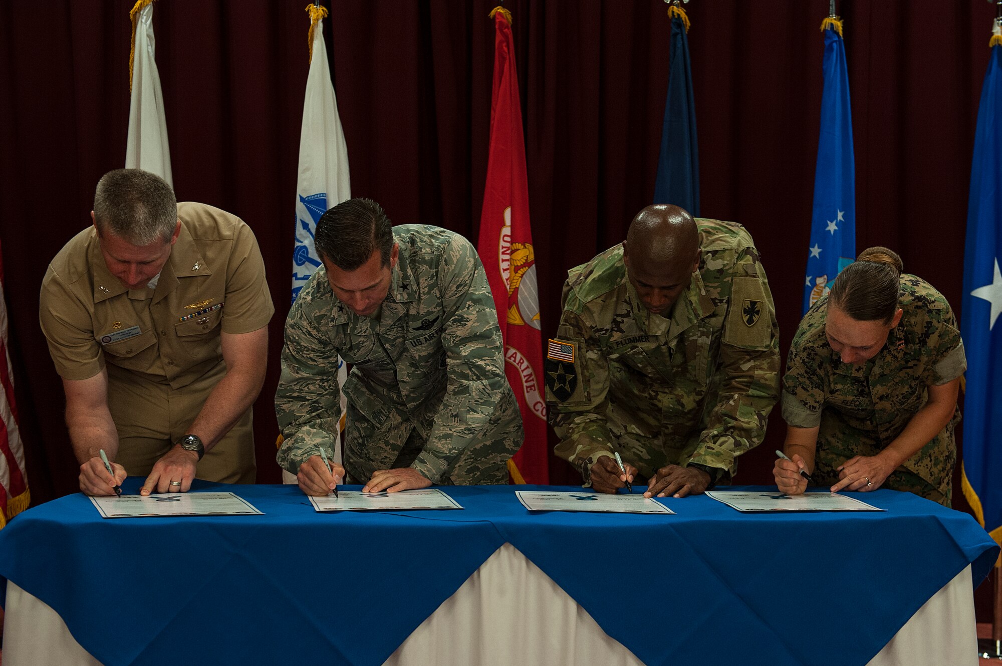U.S. Navy Capt. Robert Matthewson, Commander Fleet Activities Okinawa commander, U.S. Air Force Brig. Gen. Barry Cornish, 18th Wing commander, U.S. Army Col. Leon Plummer, 10th Regional Support Group commander and U.S. Marine Corps Capt. Sona Fleck, Marine Logistics Group Headquarters Regional Communications Company executive officer sign a proclamation declaring April as Sexual Assault Awareness and Prevention Month April 4, 2016, at Kadena Air Base, Japan. These leaders from U.S. Forces Japan-Okinawa expressed the importance of the SAPR program and that preventing sexual assault isn’t just a one month fight, but every day. (U.S. Air Force photo by Airman 1st Class Corey M. Pettis)