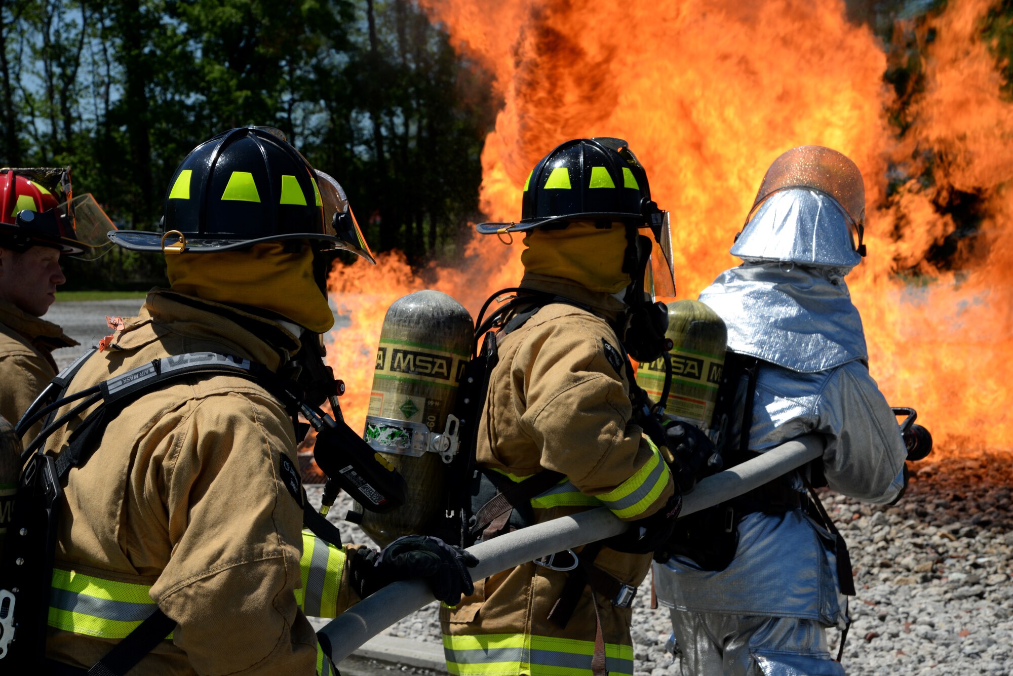 A picture of Airmen from Connecticut, Maine, New Jersey, Rhode Island and Vermont Air National Guard Fire Departments performing a live aircraft fire training exercise.