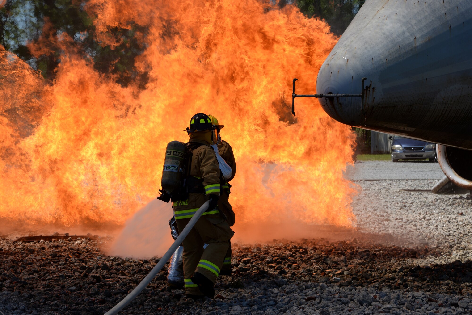 A picture of Airmen from Connecticut, Maine, New Jersey, Rhode Island and Vermont Air National Guard Fire Departments performing a live aircraft fire training exercise.