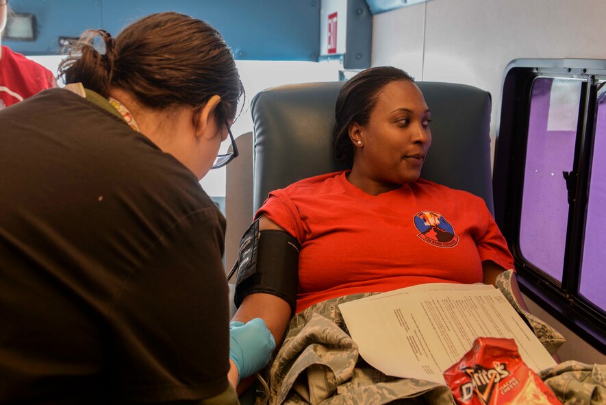 Staff Sgt. Candice Thorpe, a unit deployment manager assigned to the 23rd Bomb Squadron, takes a deep breath as the donor care specialist places the needle in her vein at a blood drive at Minot Air Force Base, N.D., March 18, 2016. Thorpe said she ate red meat for two days before the donation to be sure her iron levels were high enough to donate double red blood cells. (U.S. Air Force photo/Airman 1st Class Jessica Weissman)