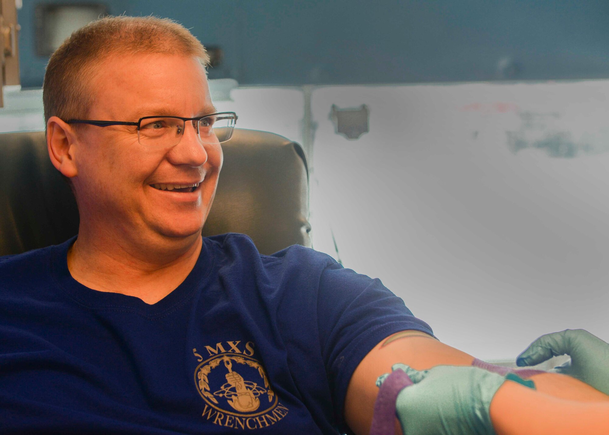 Tech. Sgt. Daniel Hubbard, an aircraft metal technology craftsman assigned to the 5th Maintenance Squadron, laughs as the donor care specialist places a needle in his vein at a blood drive on Minot Air Force Base, N.D., March 18, 2016. Hubbard said he has never donated blood on the bus but that it was a nice experience.  (U.S. Air Force photo/Airman 1st Class Jessica Weissman)
