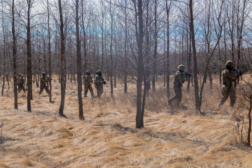 Airmen from the 791st Missile Security Forces Squadron convoy response force line up to assault an enemy ambush during a training exercise in Garrison, N.D., March 30, 2016. CRF Airmen participated in three iterations of training to prepare for the Air Force Global Strike Command Road Warrior exercise. (U.S. Air Force photo/Airman 1st Class Jessica Weissman)