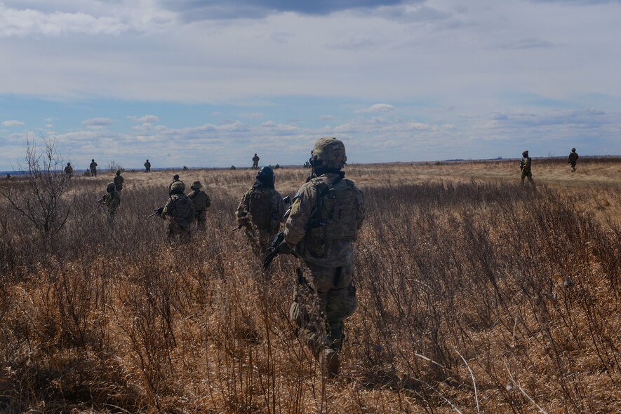 Airmen from the 791st Missile Security Forces Squadron convoy response walk in a wedge formation during a training exercise in Garrison, N.D., March 30, 2016. CRF Airmen participated in three iterations of training to prepare for the Air Force Global Strike Command Road Warrior exercise. (U.S. Air Force photo/Airman 1st Class Jessica Weissman)