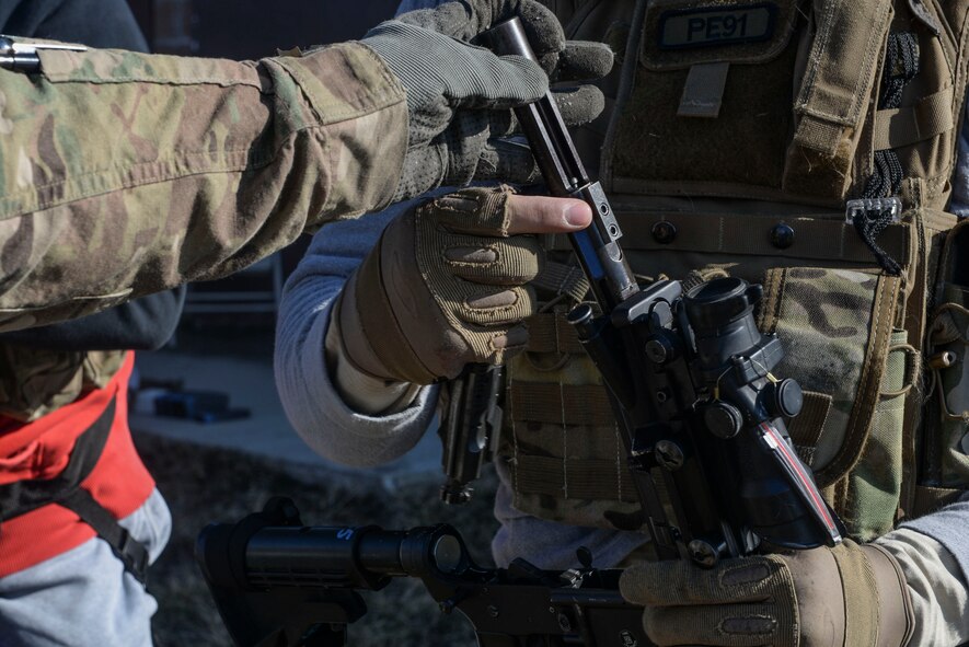 A tactical response force Airman from Minot Air Force Base, N.D. switches his live ammunition bolt to a Simunition bolt during a training exercise in Garrison, N.D., March 30, 2016. Simunition bolts allow Simunition rounds to be properly fired from a weapon during non-lethal training. (U.S. Air Force photo/Airman 1st Class Jessica Weissman)