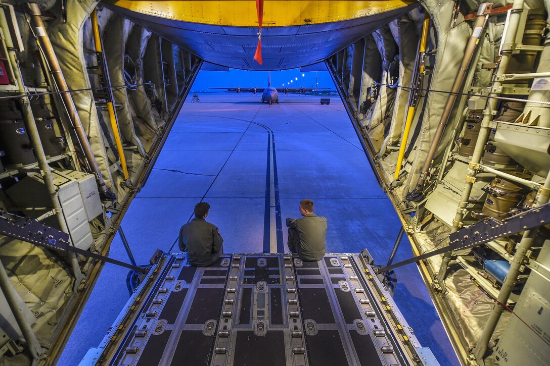 Air Force Senior Airman Nicholas McGuire, left, and Frank Morgan take a break on the ramp of a C-130J Hercules aircraft after completing a pre-flight checklist during a training mission at Dyess Air Force Base, Texas, March 30, 2016. McGuire is a loadmaster assigned to the 40th Airlift Squadron. Morgan a loadmaster is assigned to the 39th Airlift Squadron. Air Force photo by Senior Airman Keith James