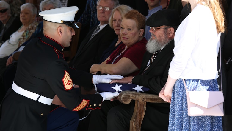 Gunnery Sgt. Clemente Batista, Staff Non-Commissioned Officer in charge of the funeral detail for Sgt. John C. Holladay, hands an American flag to Jack Holladay, the nephew of Sgt. Holladay, a World War II Marine Raider who was killed in action in 1943. After 73 years, Holladay’s remains were recently recovered and returned to his hometown of Florence, S.C., April 4, 2016. Jack said that during this process he has received nothing but support from the local community and the Marine Corps.