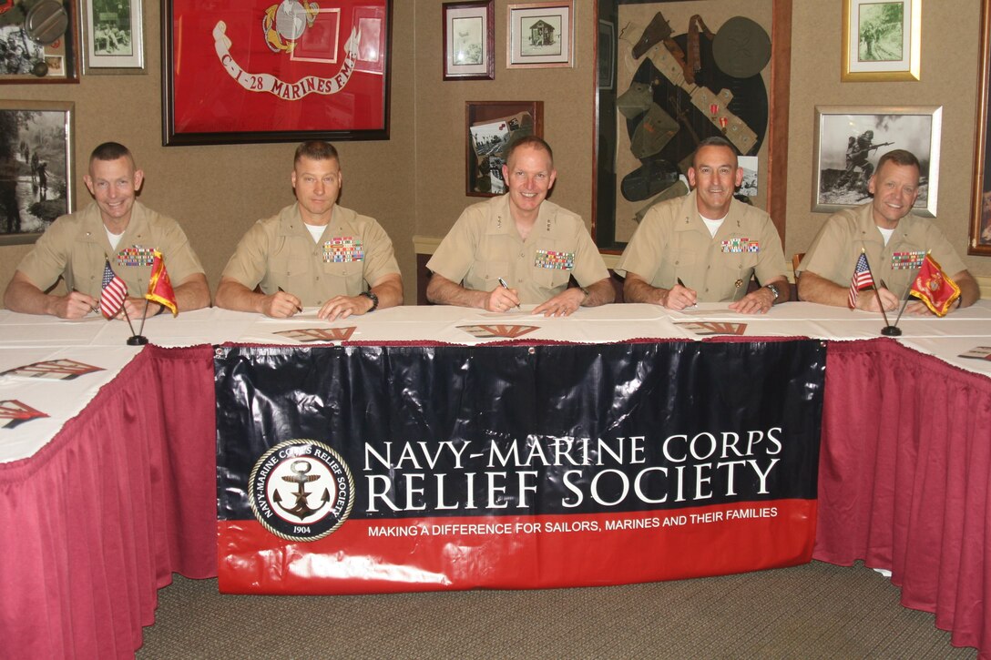 Brig. Gen. Stephen Neary, deputy commander of Marine Corps Combat Development Command; Brig. Gen. Julian Alford, commander of Marine Corps Warfighting Laboratory; Lt. Gen. Mark Brilakis, deputy commandant for Manpower and Reserve Affairs; Maj. Gen. James Lukeman, commanding general of Training and Education Command; and Brig. Gen. Joseph Shrader, commander of Marine Corps Systems Command, sign pledge forms for the Navy Marine Corps Relief Society’s 2016 fundraising drive.