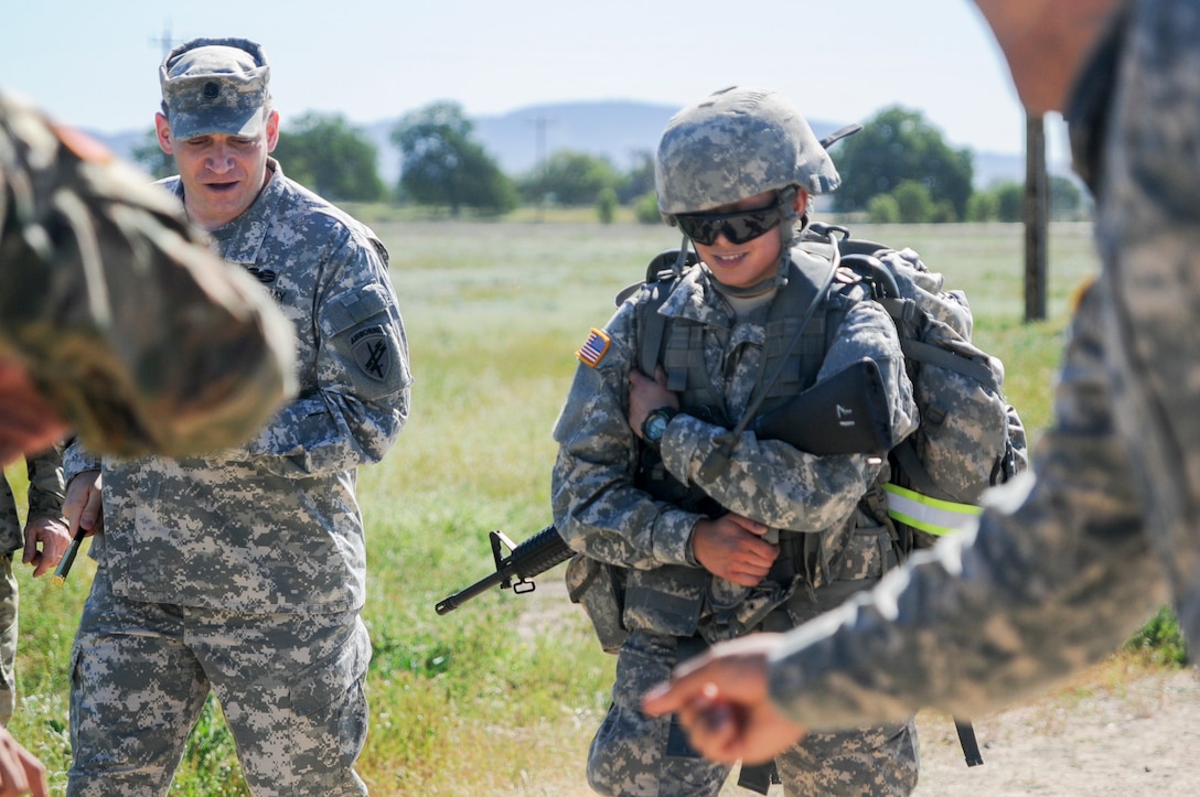 Command Sgt. Maj. Earl Rocco, the senior enlisted advisor from the 352nd Civil Affairs Command, encourages Pfc. Sarah Tuibeo, from 1st Training Brigade, during a ruck march at the U.S. Army Civil Affairs and Psychological Operations Command 2016 U.S. Army Best Warrior Competition at Fort Hunter Liggett, Calif., April 5, 2016. This year’s Best Warrior competition will determine the top noncommissioned officer and junior enlisted Soldier who will represent USACAPOC in the Army Reserve Best Warrior competition later this year. (U.S. Army photo by Spc. Khadijah Lutz-Wilcox, USACAPOC)