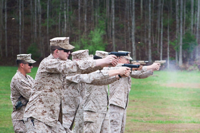 Marines from Marine Corps Combat Development Command (MCCDC) participate in a realistic line drill. The Marines fire shots in controlled pairs using the M9 or M45 to simulate realistic training.