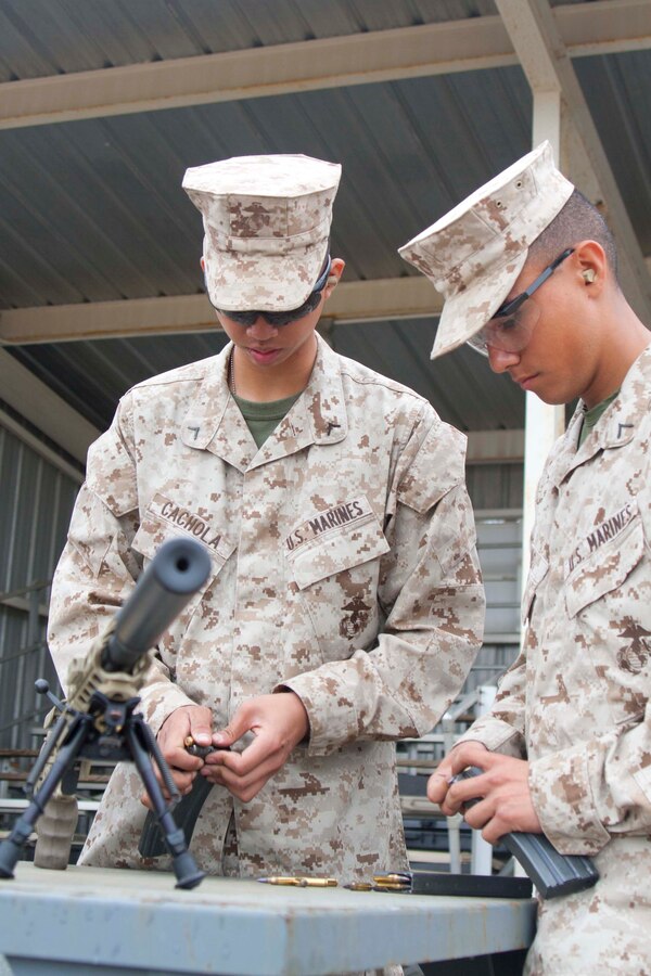 Private 1st Class Christian Cochola and Pfc. Rojas Esgar, combat camera specialist in Marine Corps Combat Development Command (MCCDC), load blacktip 5.56 ammunition. Marines had the opportunity to fire an M27, M249 SAW, and M9 and M45 service pistols.