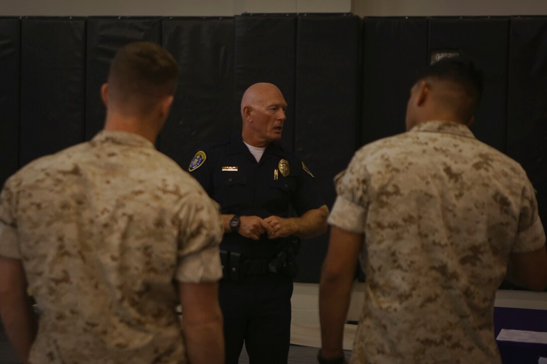 A police officer with the San Diego Police Department speaks with Marines assigned to 1st Marine Regiment, 1st Marine Division, during a career fair about the opportunities offered in the law enforcement field after leaving the service aboard Marine Corps Base Camp Pendleton, Calif., March 6, 2016. Representatives with law enforcement groups, explosive ordnance disposal units, Marine Special Operation Command, and higher education organizations participated in the fair to expose the Marines to post-service opportunities.