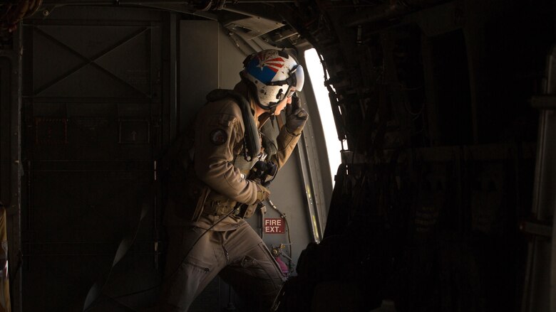 Cpl. Alec Bechtel, a crew chief with Marine Medium Tiltrotor Squadron 161 “Greyhawks”, monitors the distance of nearby aircraft during a confined area landing with Marines from VMM-165 in Southern California, March 30 2016. The training enabled Marines with VMM-161 to build interoperability between squadrons and maintain the proficiency of pilots and aircrew for these maneuvers.