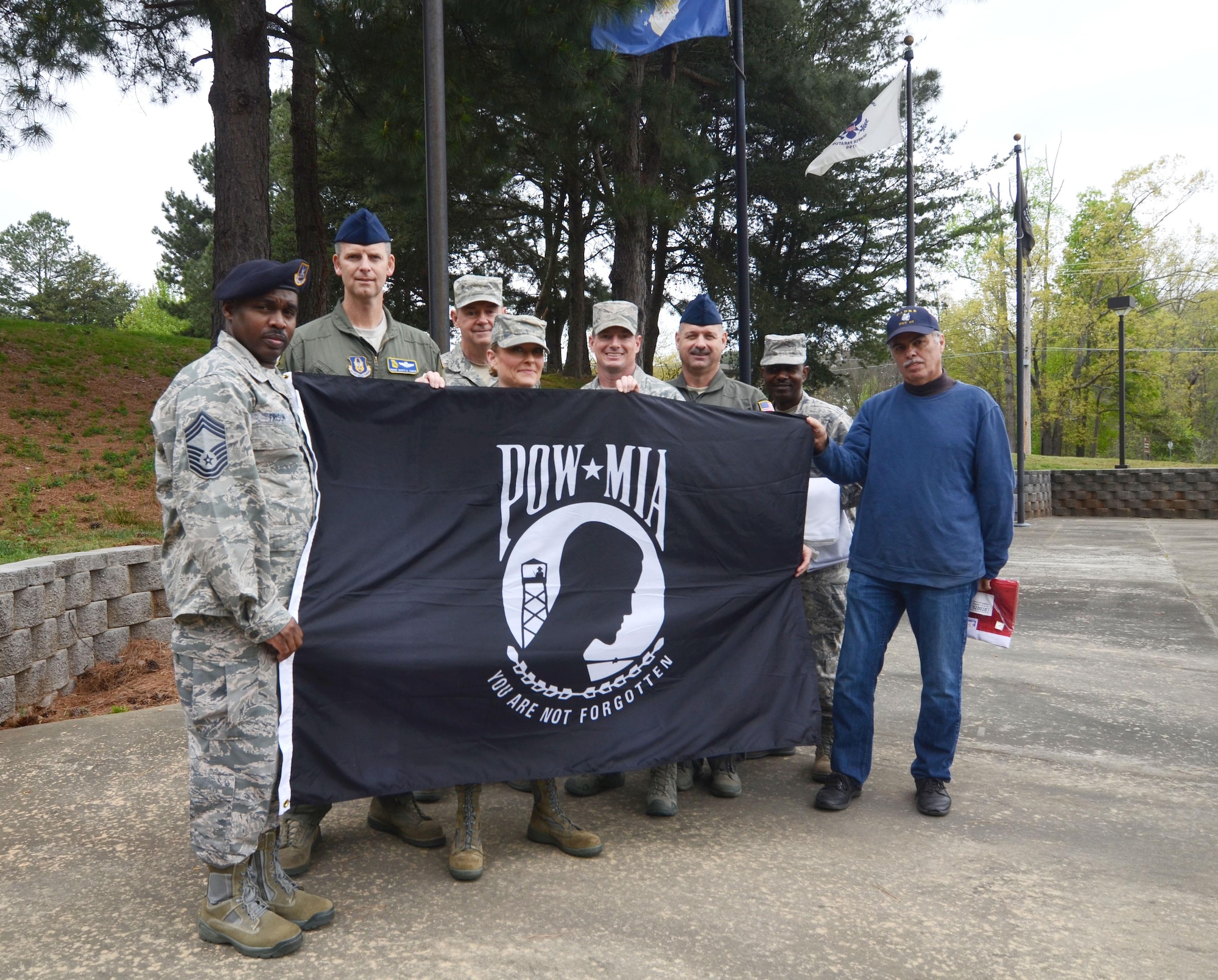 Members of the Dobbins Chiefs’ Group display a POW-MIA flag at POW-MIA Memorial Park, Dobbins Air Reserve Base, Georgia, March 31, 2016. With help from the Dobbins Thrift Store staff, the group raised seven new replacement flags at the memorial. (U.S. Air Force photo/ Don Peek)