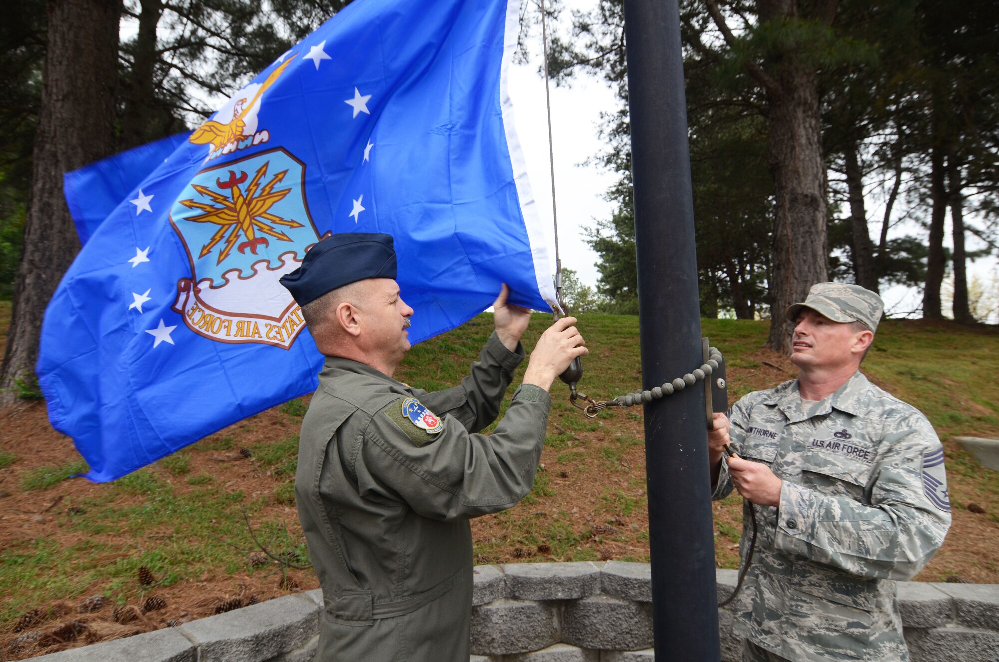 Chief Master Sgt. Terry Studstill and Chief Master Sgt. Jason Hawthorne, Dobbins Chiefs’ Group members, raise a new U.S. Air Force flag at POW-MIA Memorial Park, Dobbins Air Reserve Base, Georgia, March 31, 2016. With help from the Dobbins Thrift Store staff, the group raised seven new replacement flags at the memorial. (U.S. Air Force photo/ Don Peek)