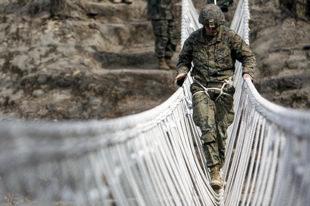 A U.S. Marine crosses a river on a rope bridge as a part of the Korean Marine Exchange Program in South Korea, March 31, 2016. The program is designed to increase interoperability and camaraderie between U.S. and South Korean marines. Marine Corps photo by Lance Cpl. Sean M. Evans

