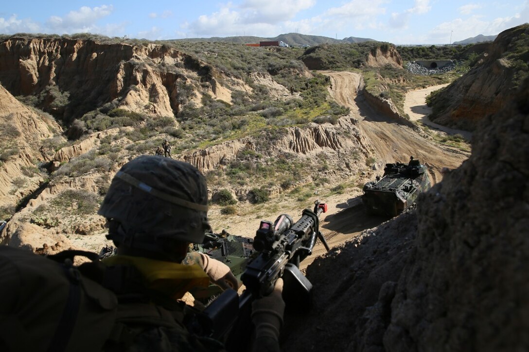 A Marine with Company B, 1st Battalion, 4th Marines, provides security overwatch as Amphibious Assault Vehicles pass below after conducting an amphibious landing during Co. B’s Marine Corps Combat Readiness Evaluation aboard Marine Corps Base Camp Pendleton, Calif., March 29, 2016. After the amphibious landing, the Marines made their way toward a combat town, where they assaulted through the urban environment. (U.S. Marine Corps photo by Lance Cpl. Timothy Valero/ Released) GREAT SHOT!