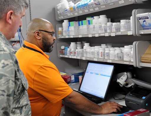 Dwain Hedgepeth, 22nd Medical Support Squadron supply custodian, demonstrates the base pharmacy procedures to Col. Albert Miller, 22nd Air Refueling Wing commander, March 31, at McConnell Air Force Base, Kan. Miller visited the clinic to better understand how patients are processed through the line and how electronic prescriptions are filled and tracked in the system. (U.S. Air Force photo/Senior Airman David Bernal Del Agua)