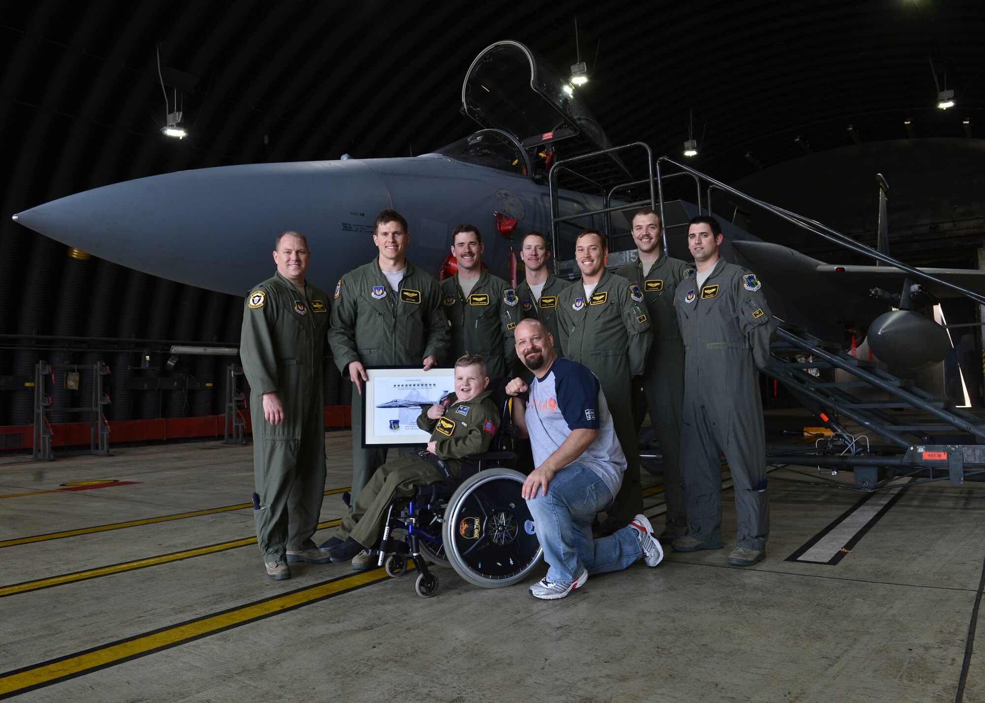 Carson Jones, a seven-year-old “Pilot for a Day” participant, poses for a photo with 493rd Fighter Squadron pilots during a base tour at Royal Air Force Lakenheath, England, March 31, 2016. Carson toured various units around the base and interacted with pilots and Airmen to gain a better understanding of the base’s mission. (U.S. Air Force photo/Senior Airman Nigel Sandridge)
