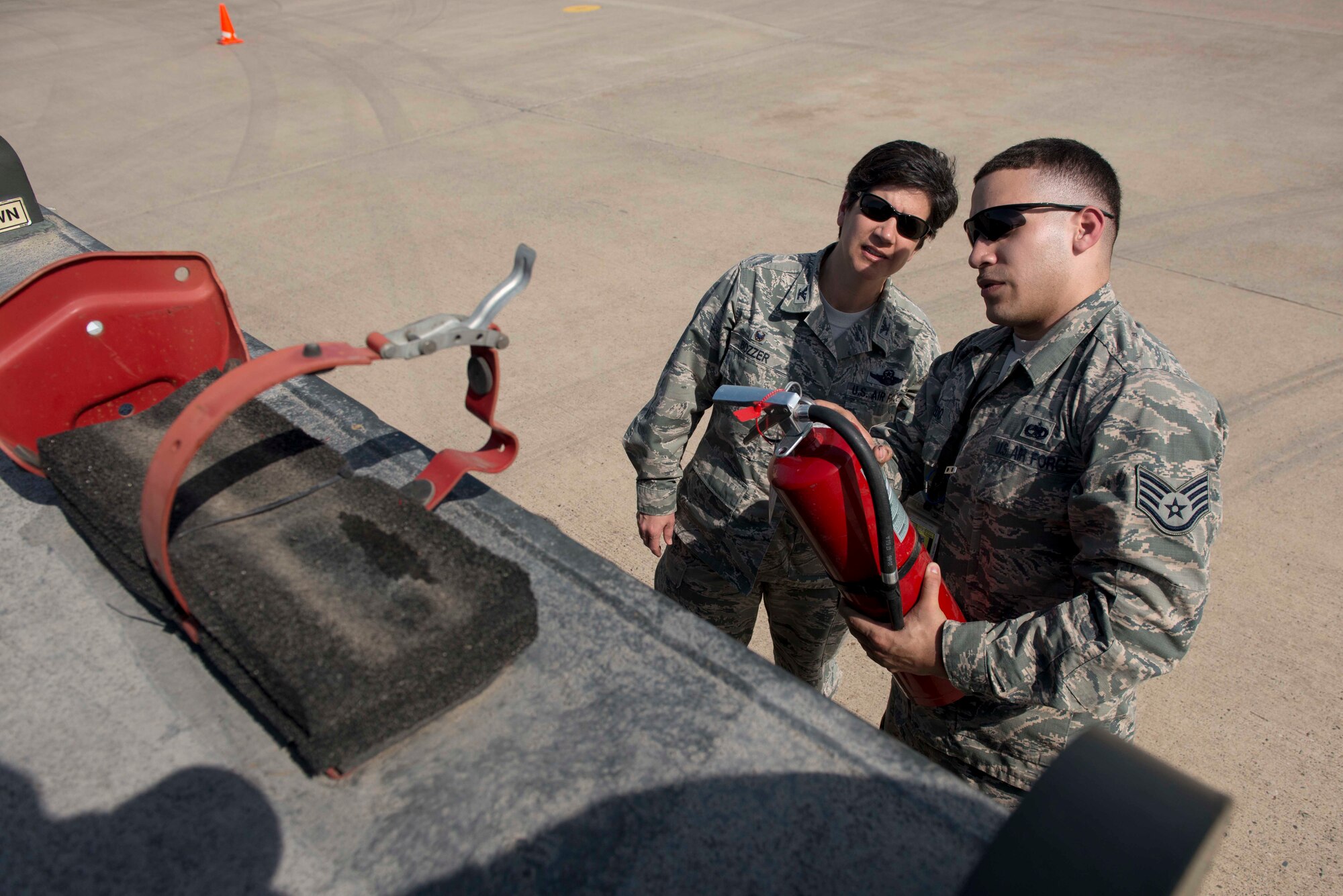 U.S. Air Force Staff Sgt. Michael Salcedo, 728th Air Mobility Squadron crew chief, inspects a fire extinguisher with U.S. Air Force Col. Nancy Bozzer, 521st Air Mobility Operations Wing commander, April 5, 2016, at Incirlik Air Base, Turkey. Inspecting the fire extinguisher was part of a pre-vehicle operations walkthrough check. (U.S. Air Force photo by Senior Airman John Nieves Camacho/Released)