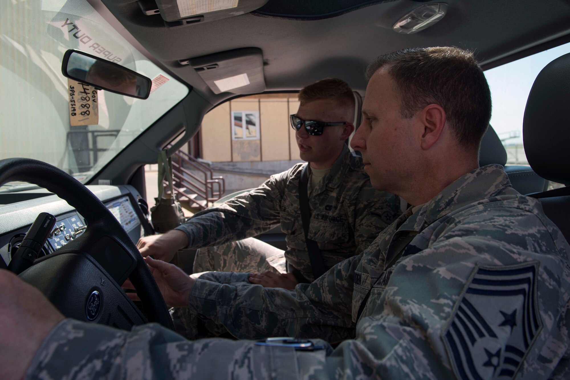 U.S. Air Force Airman Evan Fisher, 728th Air Mobility Squadron passenger service agent, demonstrates staircase truck functions to U.S. Air Force Chief Master Sgt. Mark Redden, 521st Air Mobility Operations Wing command chief, April 4, 2016, at Incirlik Air Base, Turkey. Staircase trucks are used to transit passengers on and off aircraft. (U.S. Air Force photo by Senior Airman John Nieves Camacho/Released)