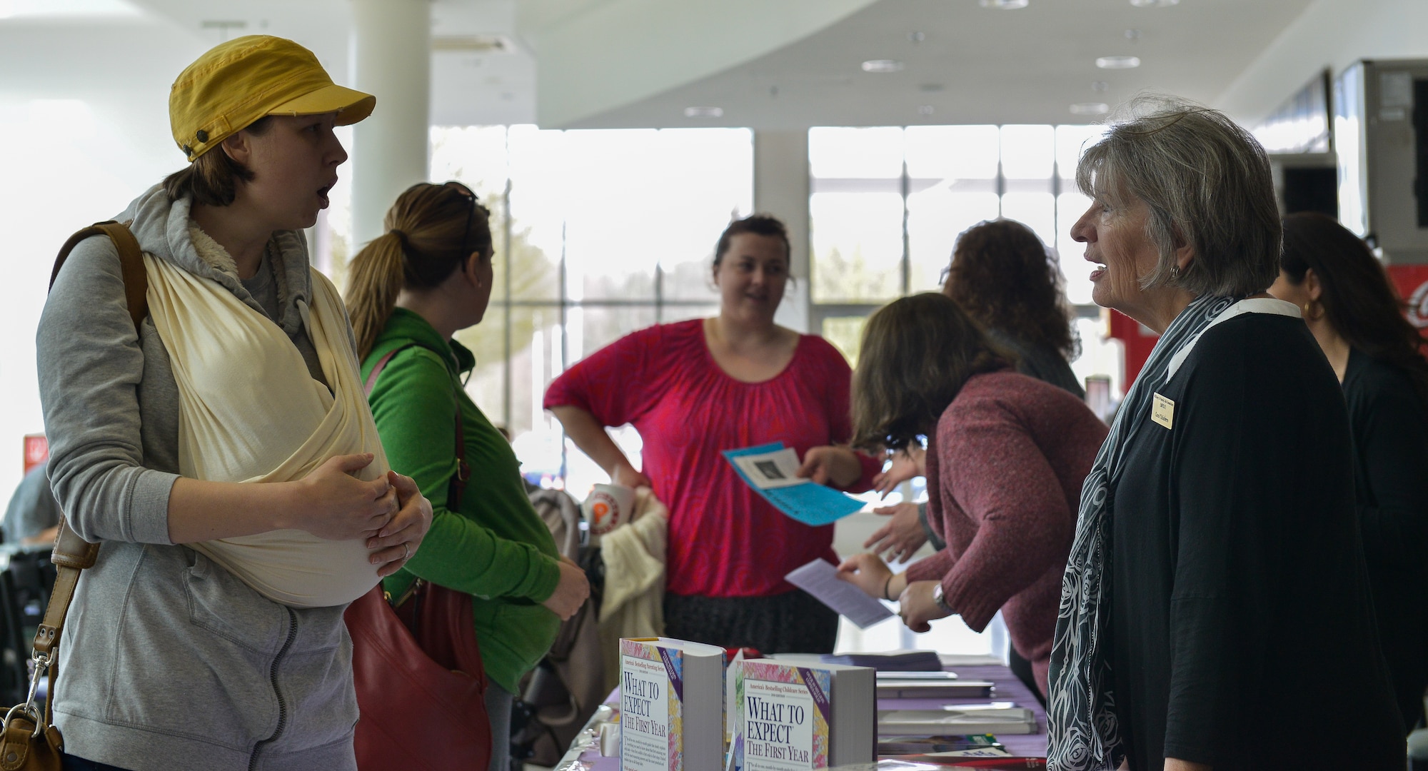 Sara Jordan (left) visits the kiosk for the Purple Crying: Understanding Your Crying Baby display April 6, 2016, at Ramstein Air Base, Germany. The display is part of National Child Abuse Awareness Month and allows parents to come together and learn how to better read distressed infants’ body language. (U.S. Air force photo/Airman 1st Class Lane T. Plummer)