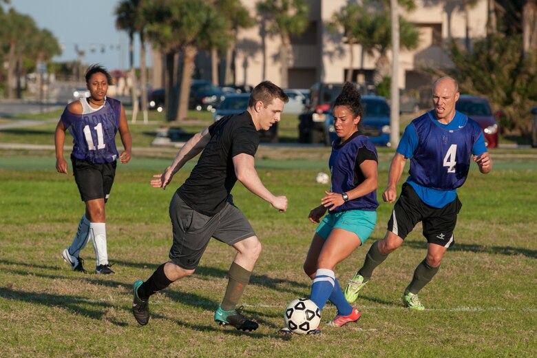 Staff Sgt. Zachery Dunphy, 45th Medical Group, attempts to kick the ball away from the opposing team, 45th Operation Support Squadron, during Patrick Air Force Base’s intramural soccer double elimination tournament April 5.  Although, the MDG won the semifinal game of the season scoring a victory over the 45th OSS, the 45th OSS ultimately won the base championship title.  Eight base teams were vying for the win during the tournament. (U.S. Air Force photo by Benjamin Thacker/Released)